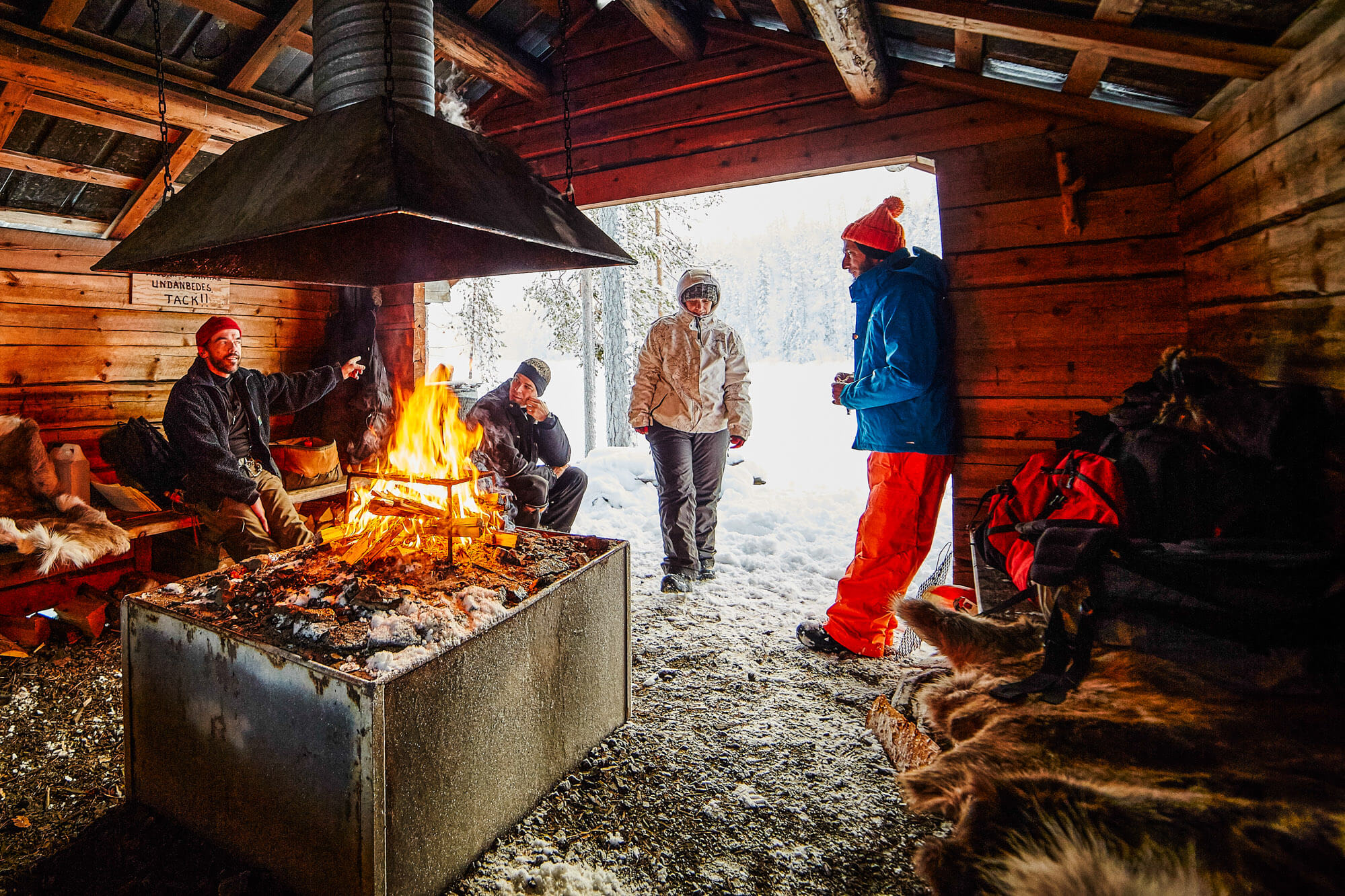 Lunch break around a wood fire in a cabin in Swedish Lapland