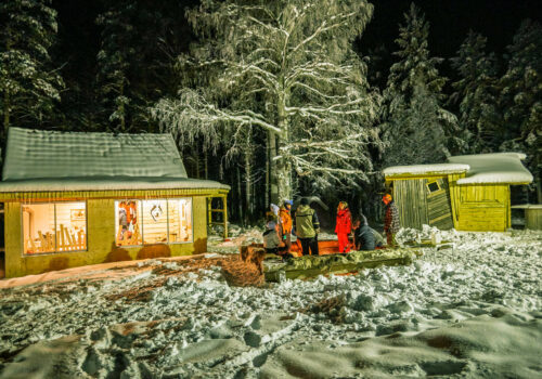 Un groupe autour du feu au retour d'un raid en chiens de traîneaux en Laponie