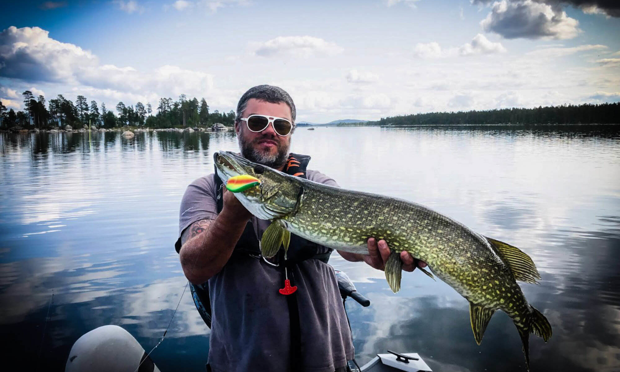 Un pêcheur posant avec son beau brochet en Laponie suédoise