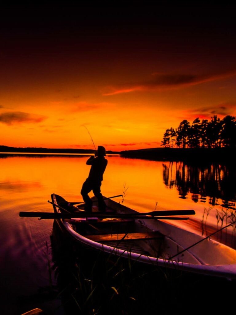 Un pêcheur au coucher du soleil en laponie suédoise