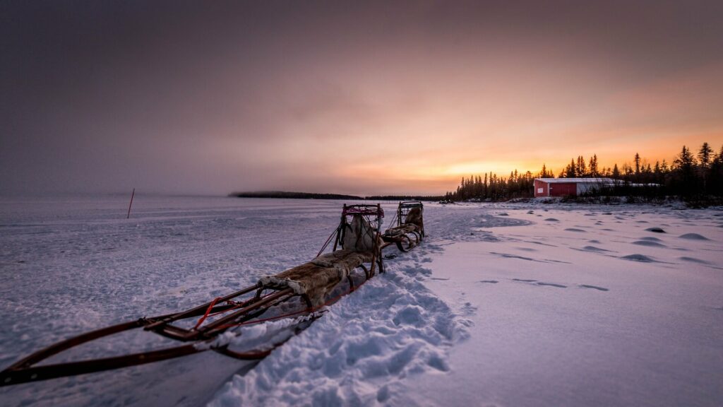 Deux traîneaux en bois sous un coucher de soleil