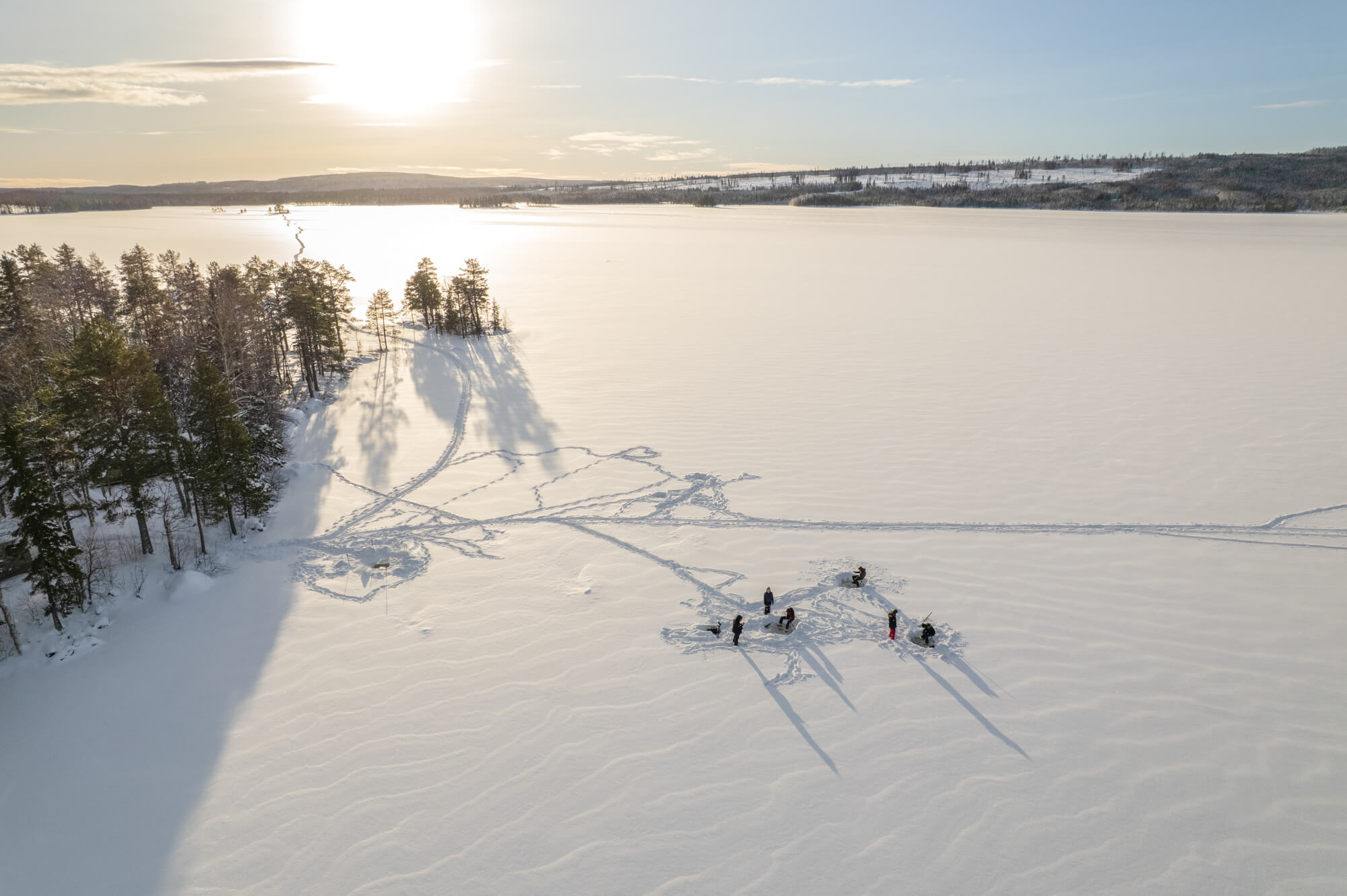 avis-voyageurs-suede-laponie-flarken-adventure-250 Vue de drone d'un groupe de touristes sur un lac gelé en Laponie, Suède