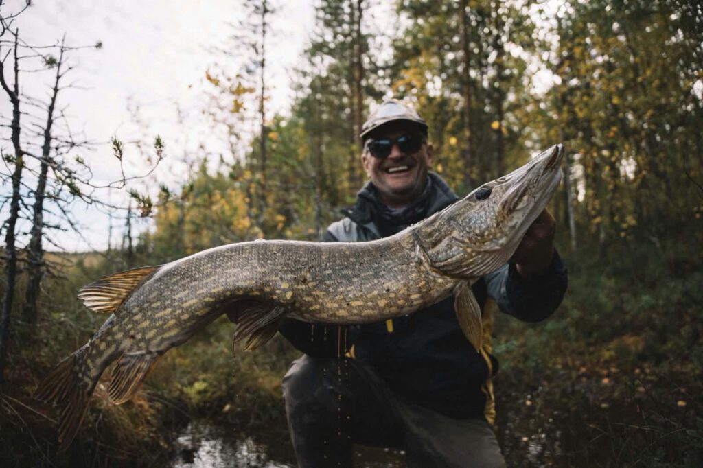 Un pêcheur pose avec un brocht géant en Laponie @Flarken Adventure